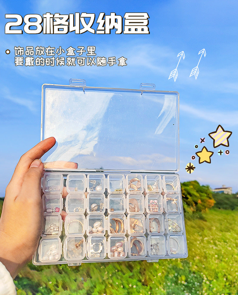 Transparent IBG jewelry storage box with multiple compartments for organizing rings, necklaces, and earrings.