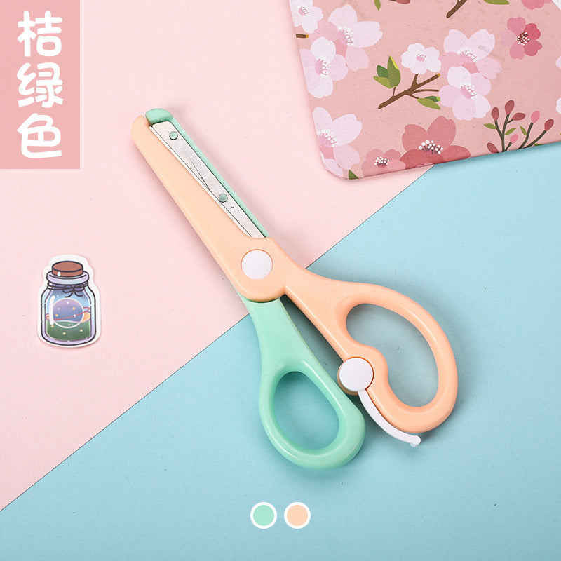 Kids safety scissors with macaron-colored handles, designed for children and school use, by IBG, shown with open blades.